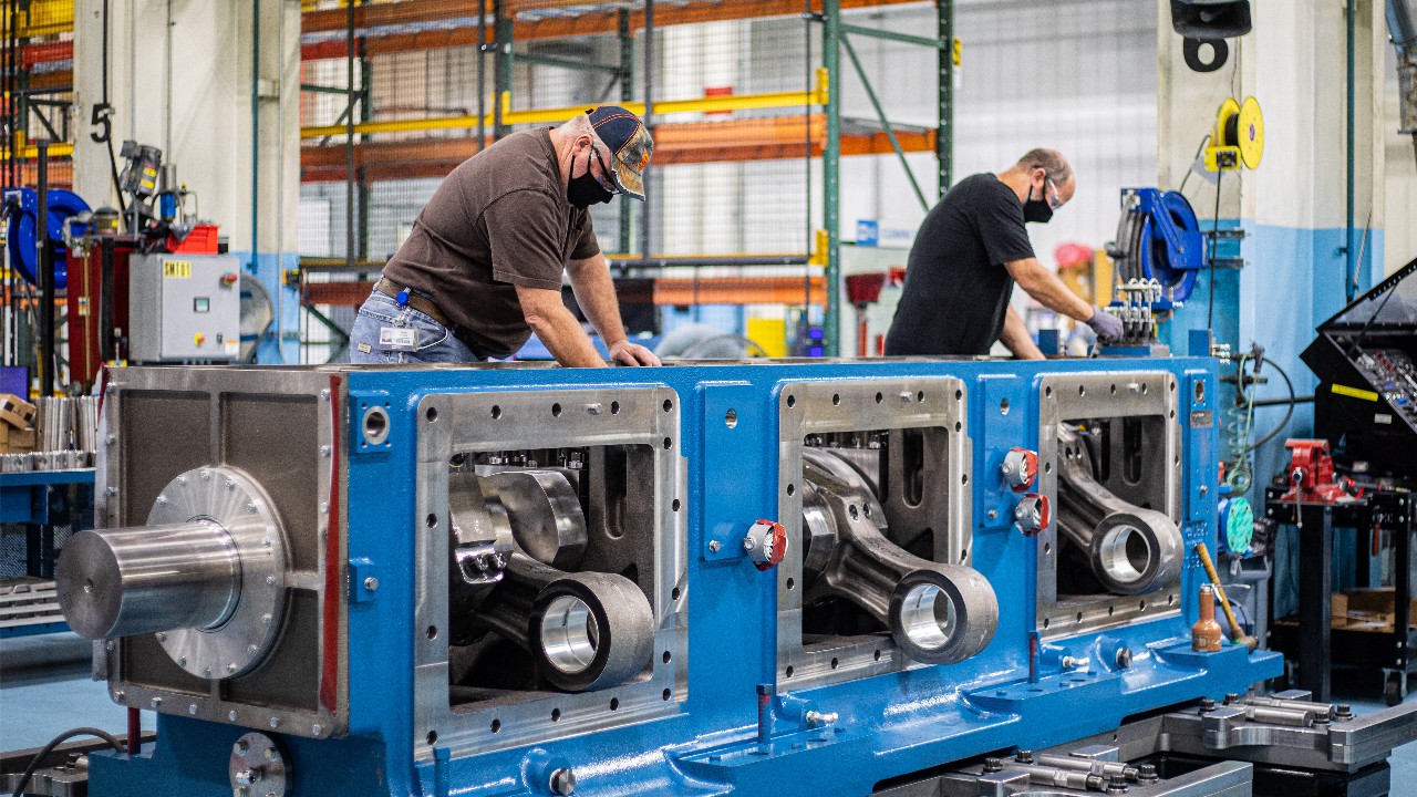 Two Ariel employees assembling an Ariel compressor