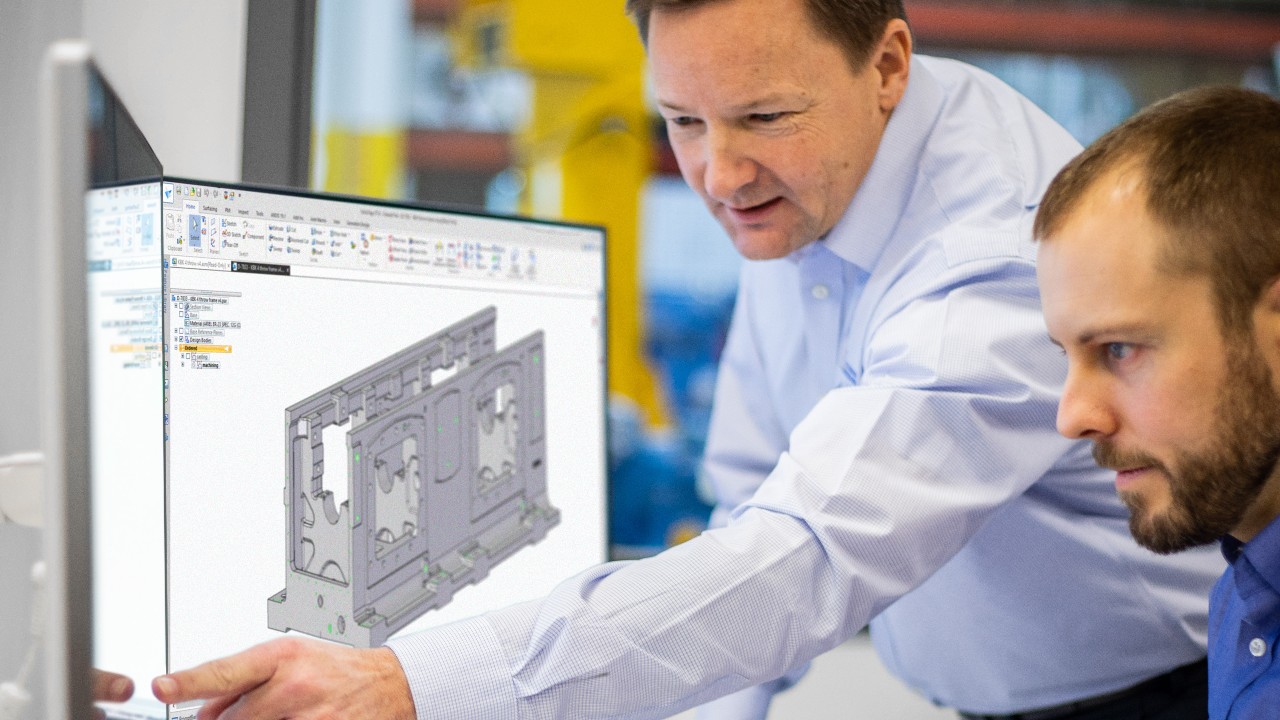 Two Engineers designing a compressor frame with 3D rendering software