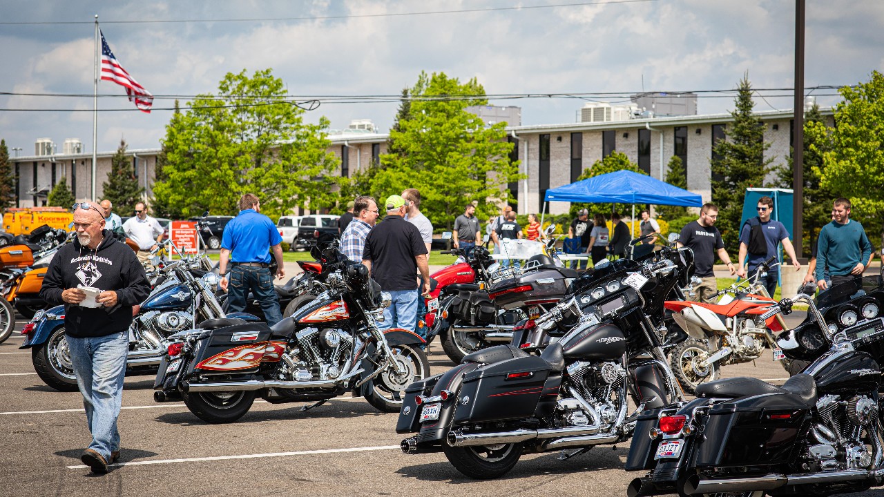 Ariel employees gather around motorcycles and classic cars for the annual Ariel Cruise In