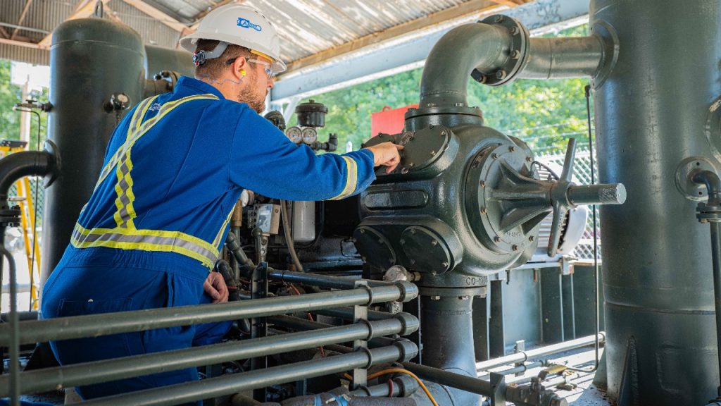 An ariel technician checking on a compressor at an artex compressor station
