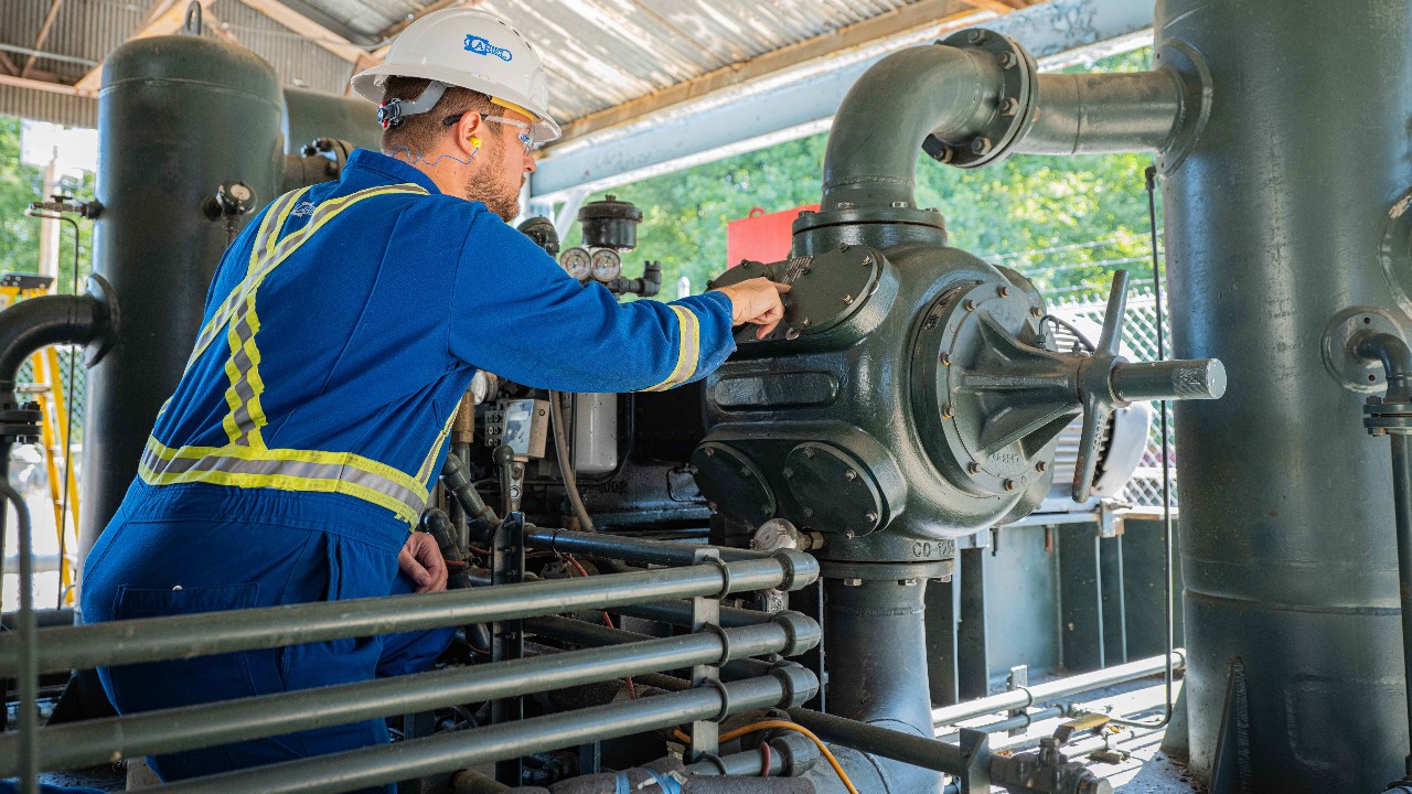 An ariel technician checking on a compressor at an artex compressor station