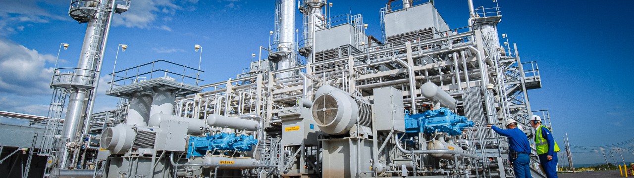 Two Ariel field workers analyze a compressor at a hydrogen plant