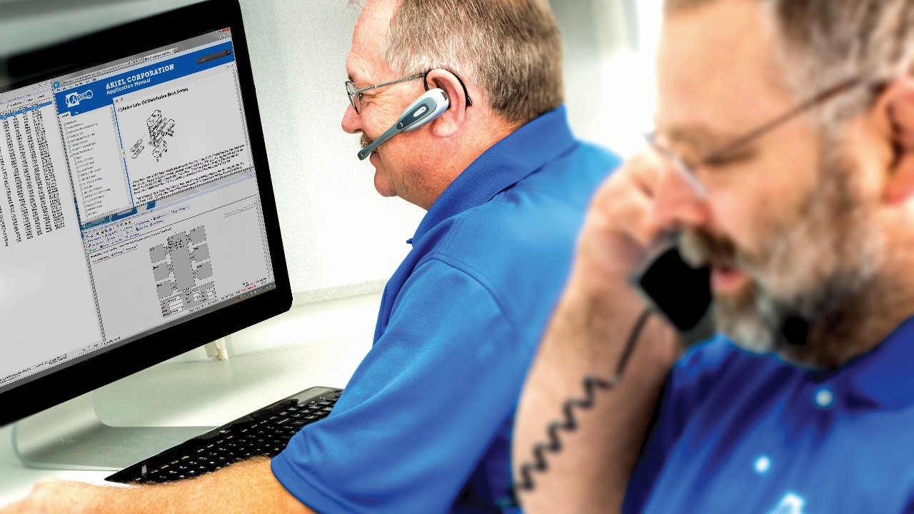 Two ARC technicians responding to calls on the phone and on the computer