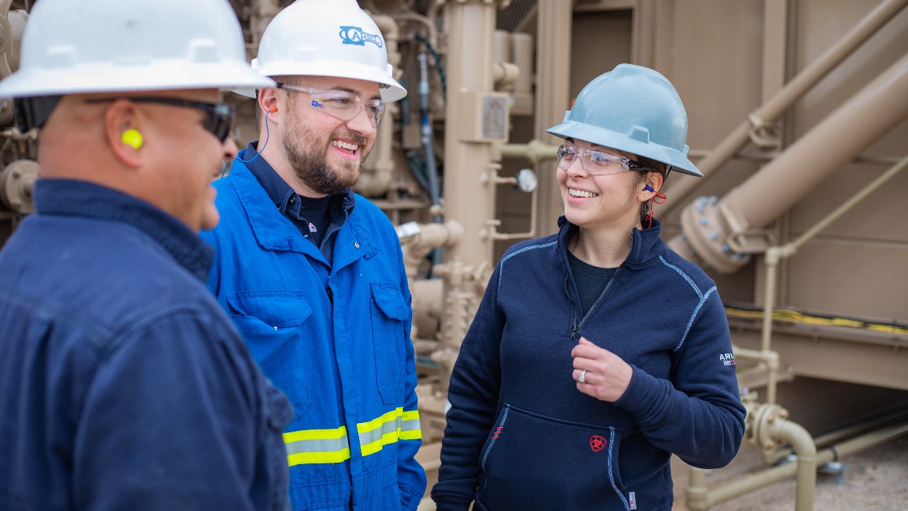 Ariel field technician speaking with a mechanic and a supervisor at a compressor station